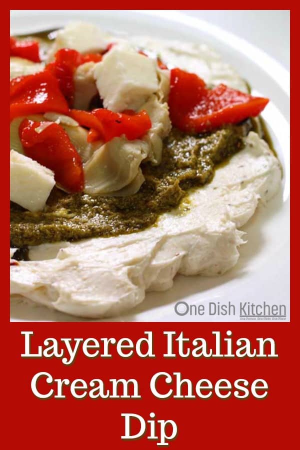 Layered Italian Cream Cheese dip, an easy to make spread topped with pesto, artichoke hearts, roasted red peppers and mozzarella cheese. | One Dish Kitchen | #holiday #holidayrecipes #Christmas #dips #party #appetizer #pesto