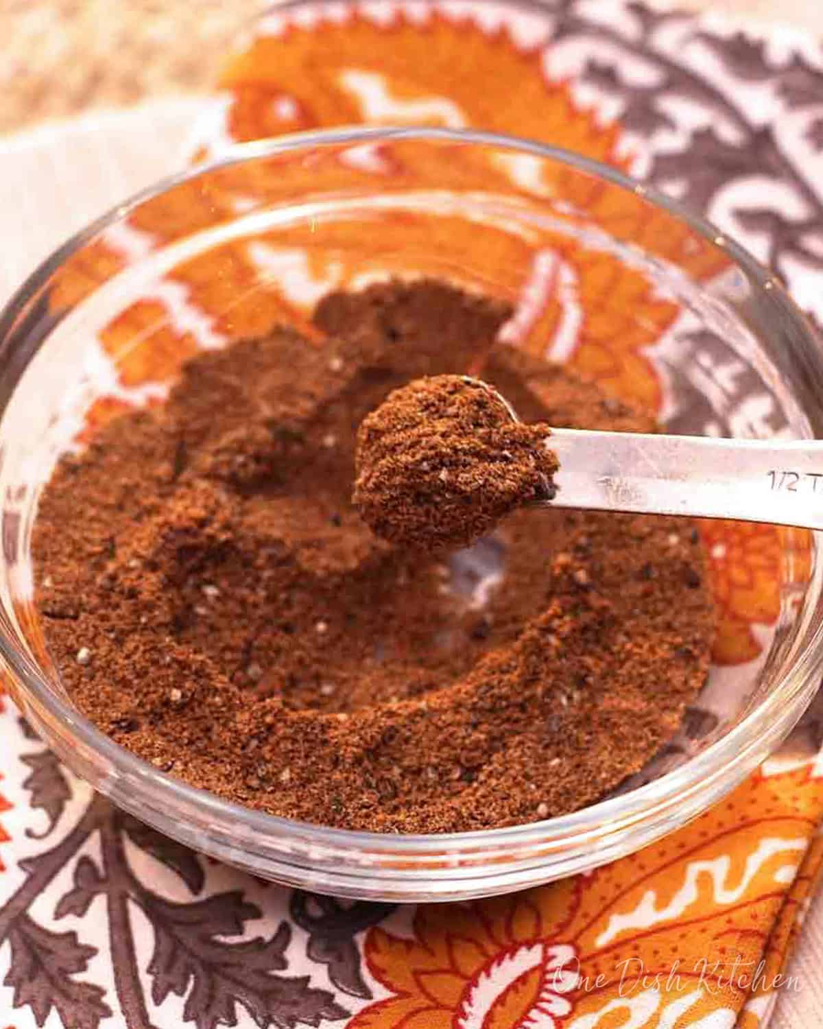 a bowl of garam masala on a yellow napkin.