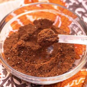bowl of garam masala spice with a measuring spoon on the side