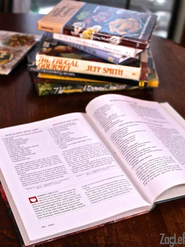 stack of cookbooks on a brown wooden table