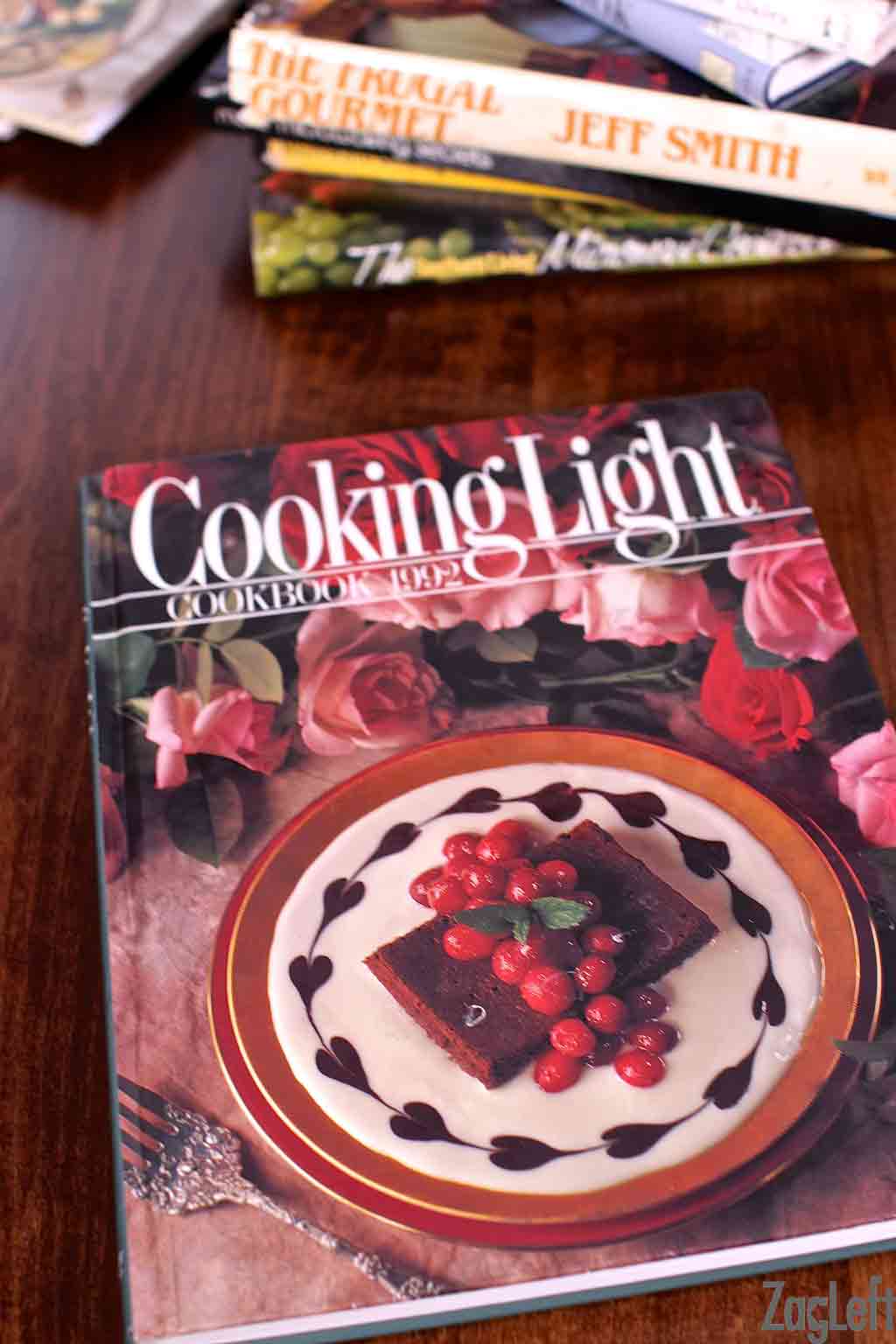 A closeup of a vintage Cooking Light cookbook from 1992 on a wooden table 