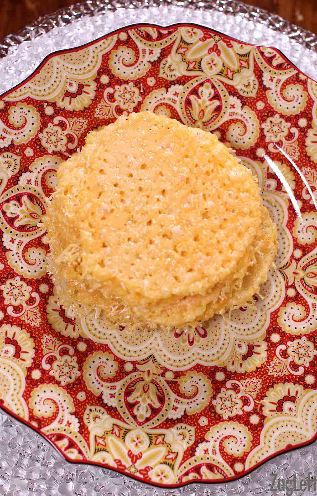 Parmesan cheese crisps stacked on a plate.