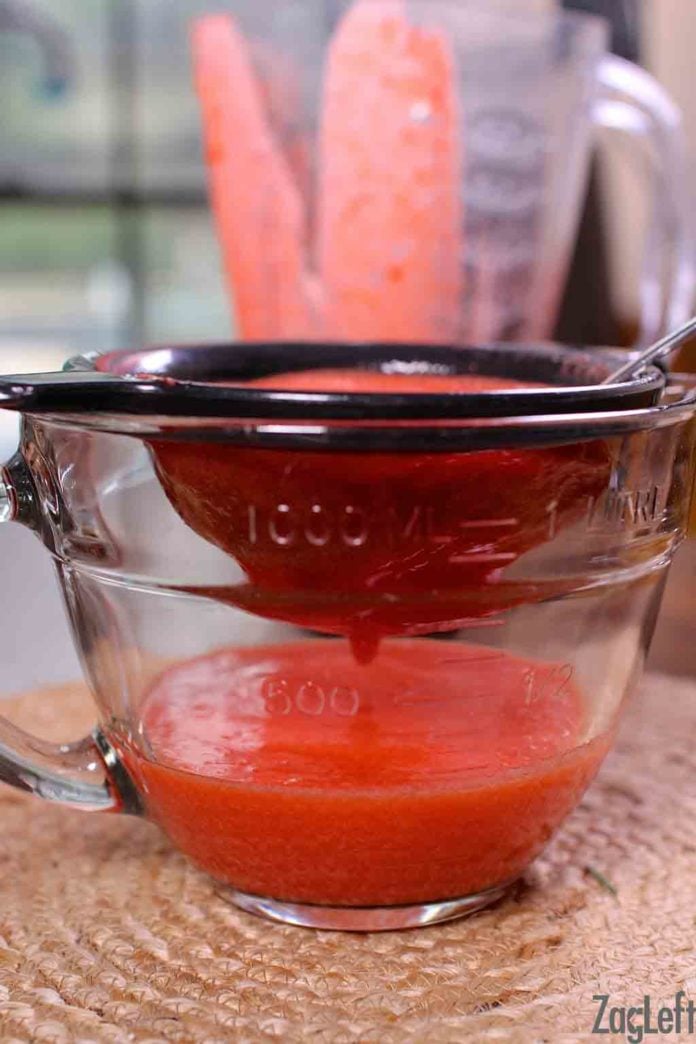 Strawberry puree in a one liter mixing bowl with a strainer