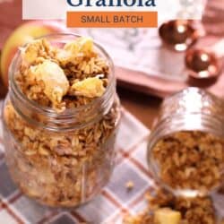 a mason jar filled with baked apple granola with another jar of granola turned on its side.