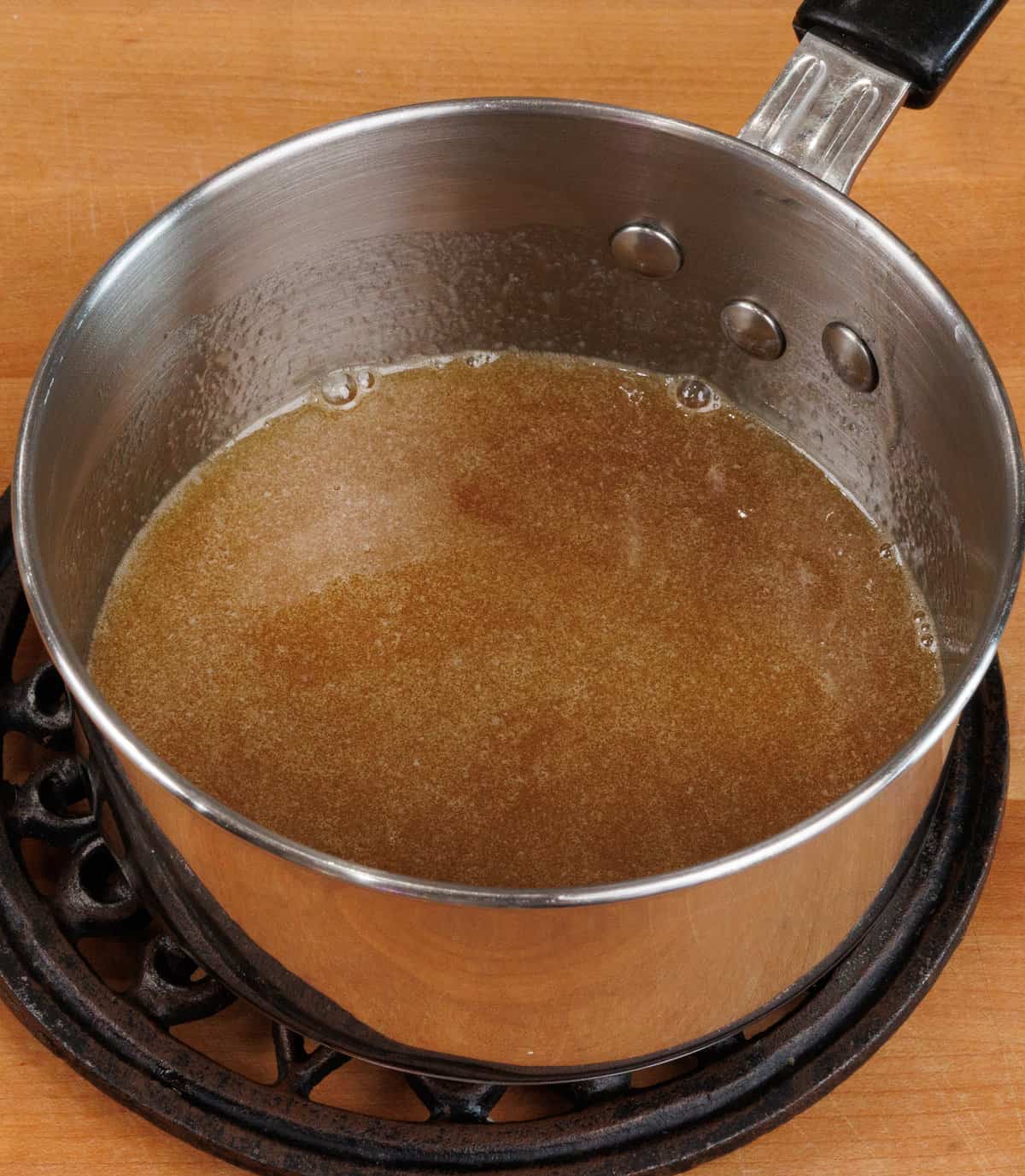 melted butter, maple syrup and vanilla in a small pot on a counter.