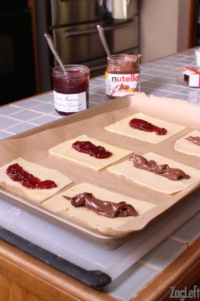 Spooning the filling of jam and nutella onto the dough.