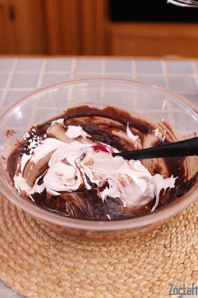 Egg whites folded in chocolate mixture in glass bowl