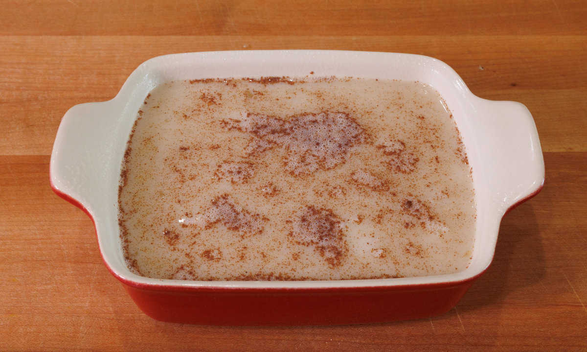 uncooked rice pudding in a small red baking dish