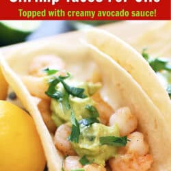 one shrimp taco topped with avocado sauce and chopped cilantro on a plate