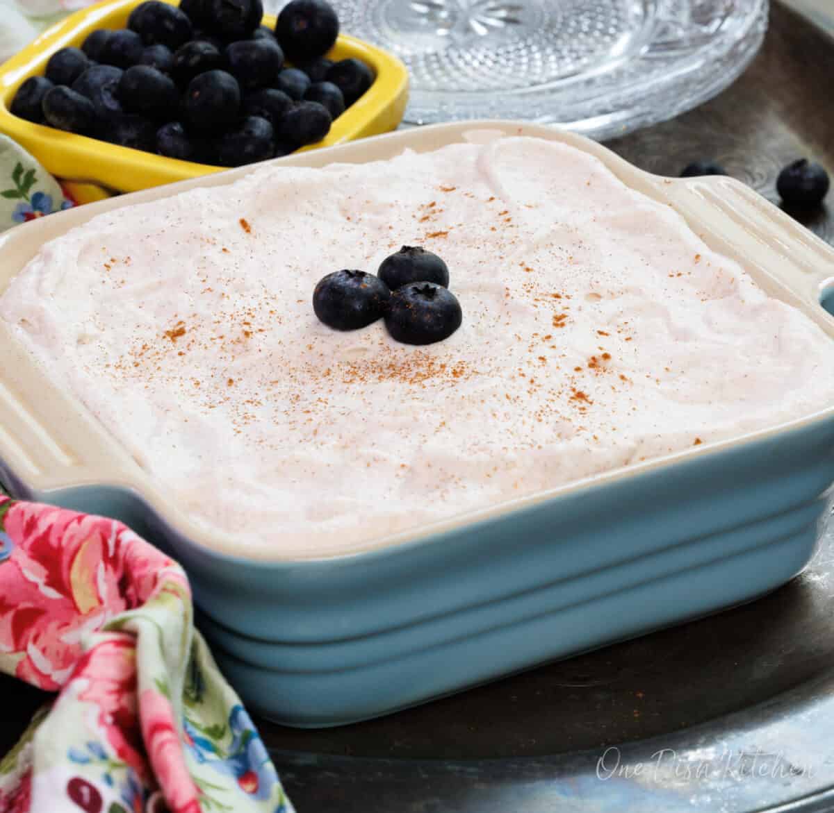 a small tres leches cake in a blue baking dish