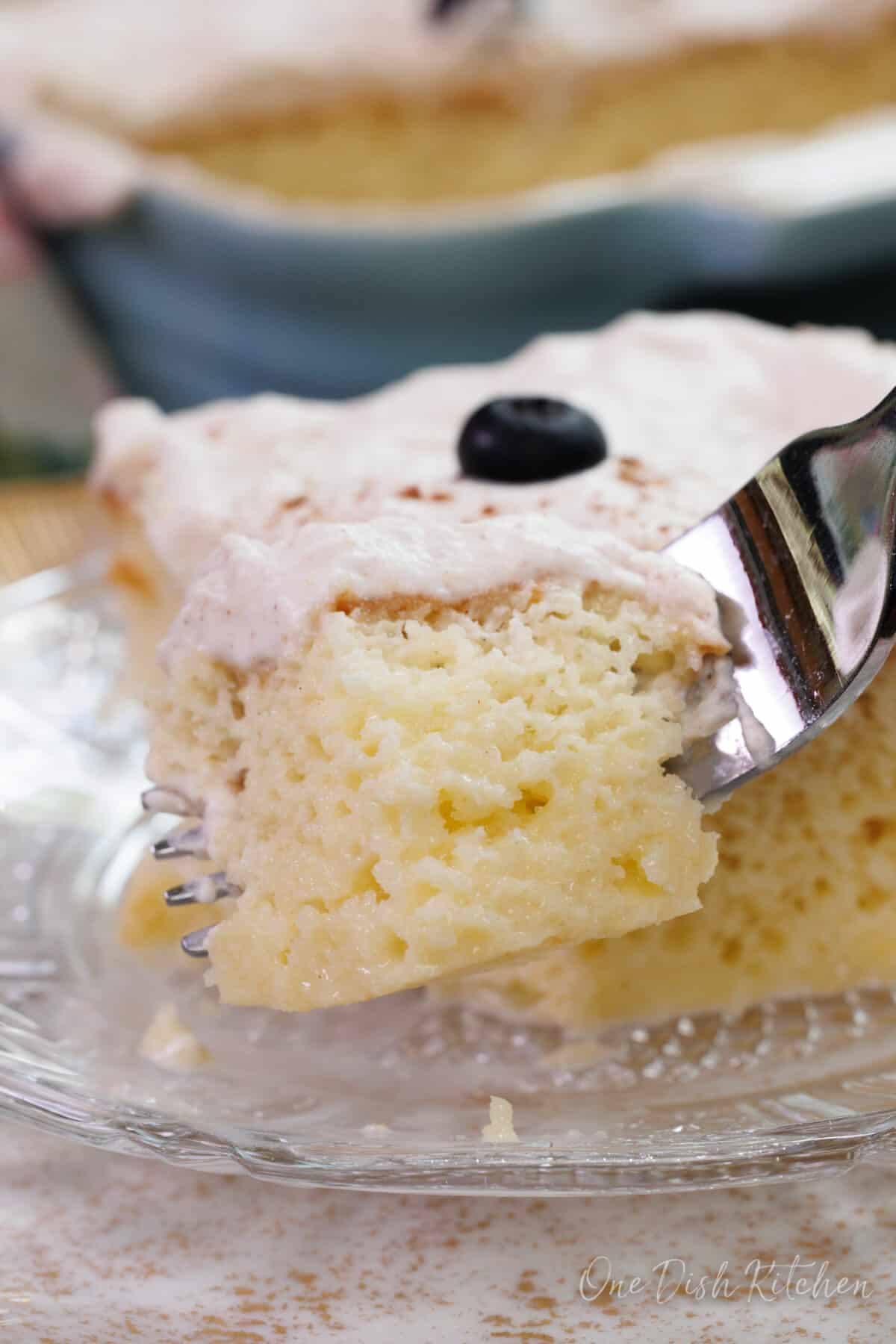 limoncello tres leches cake on a plate with a fork on the side