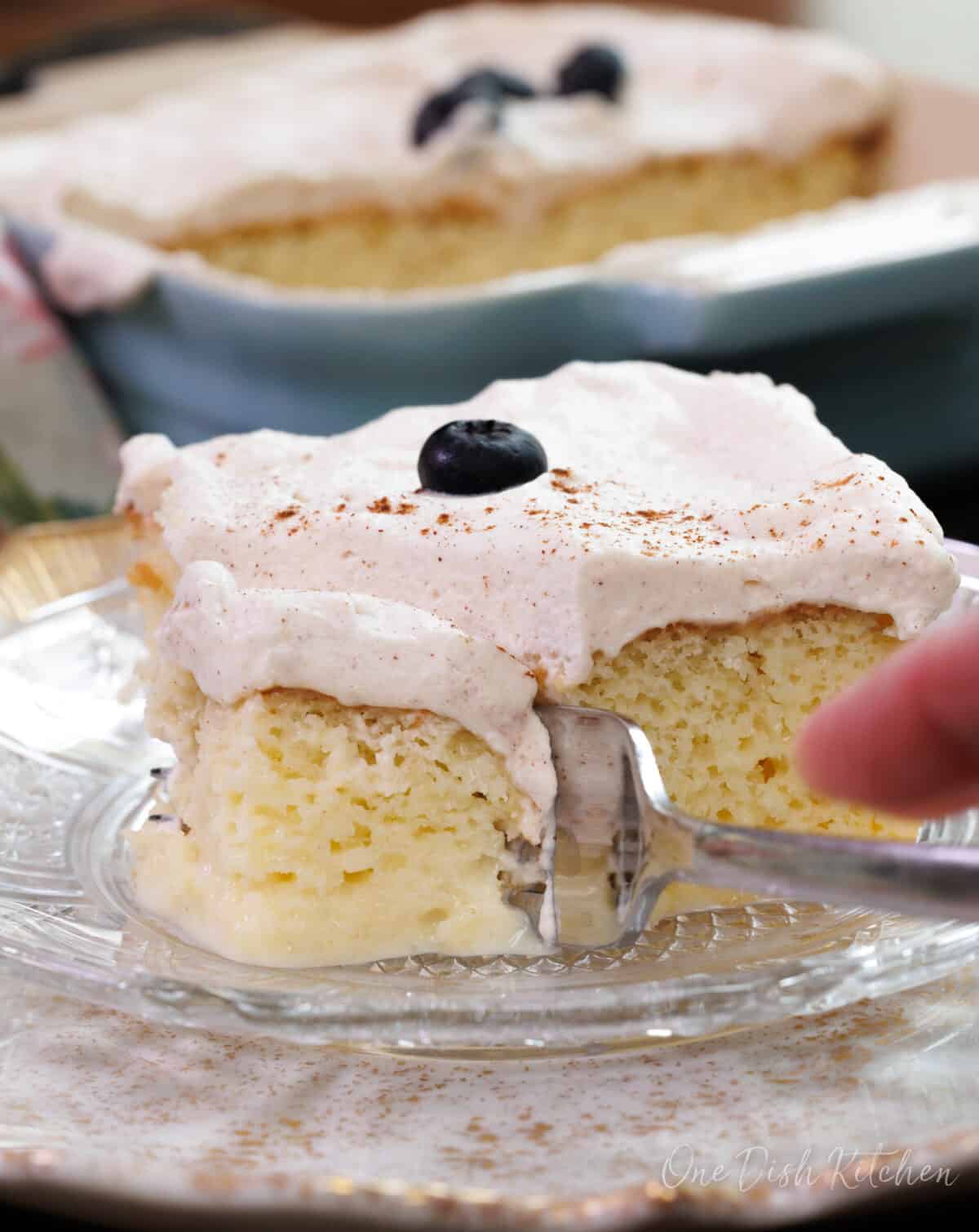 a fork scooping up a bite of tres leches cake