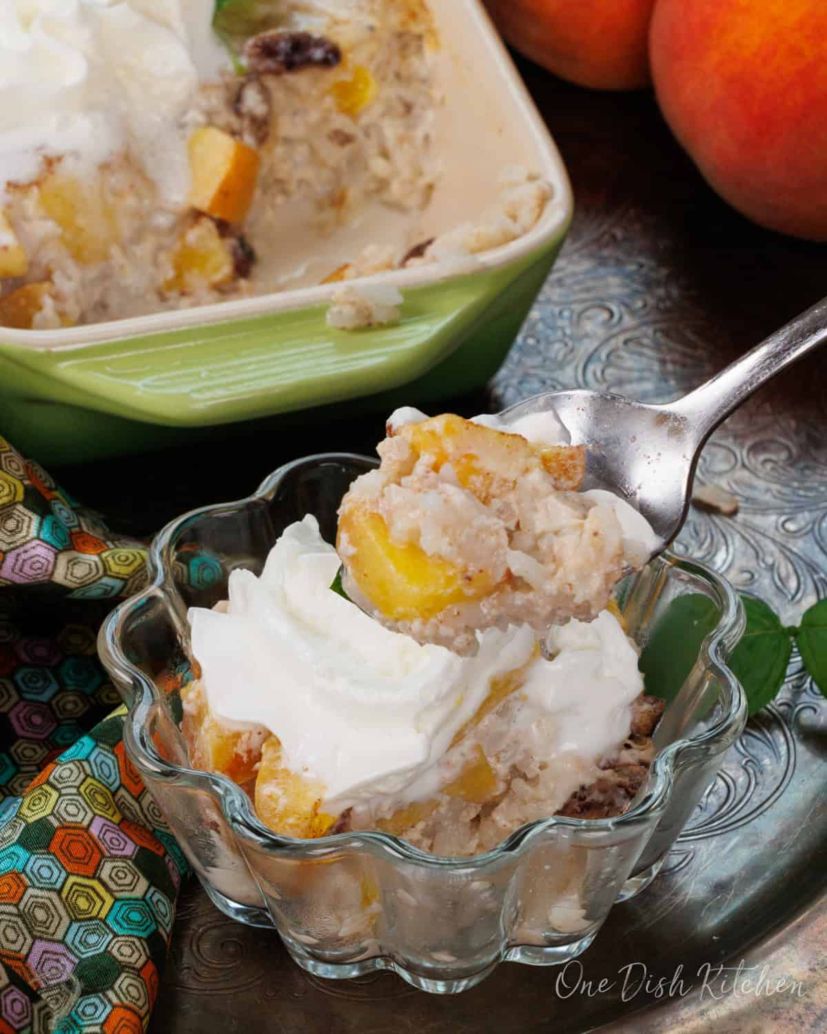 a bowl of peach rice pudding topped with whipped cream.