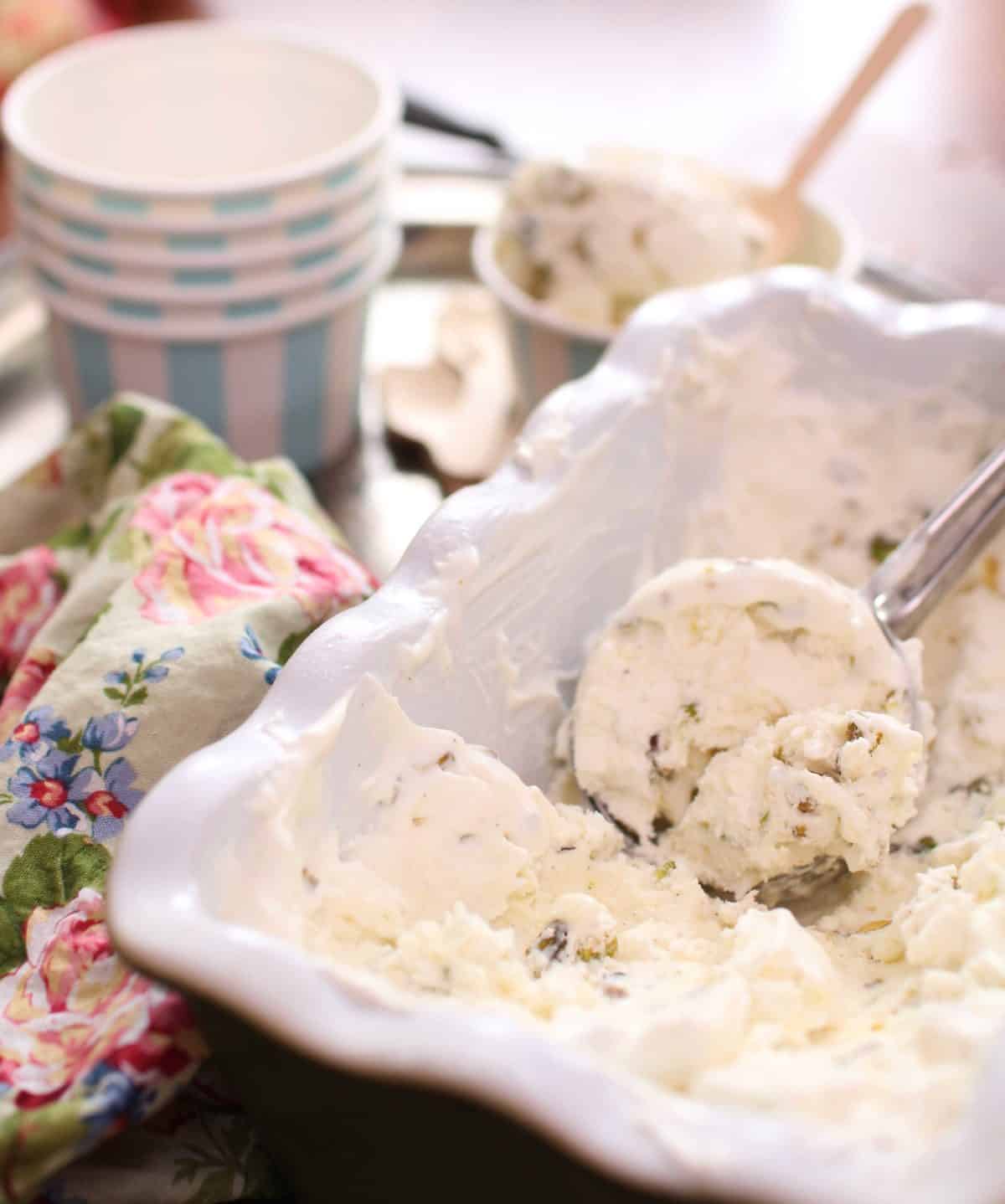a bowl of pistachio ice cream with a scoop in the center.
