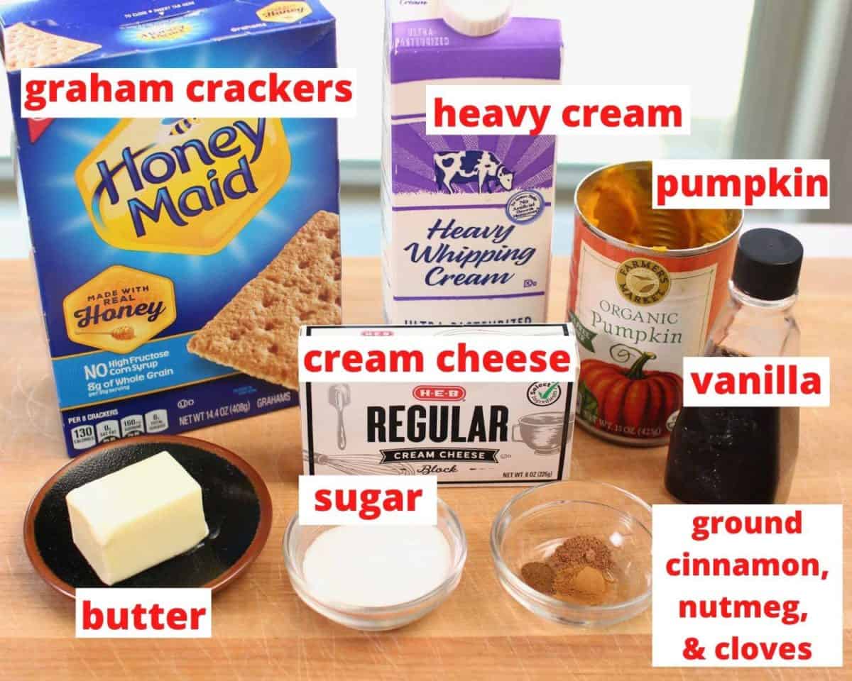 ingredients needed for a no bake pumpkin cheesecake on a wooden table all labeled in red.