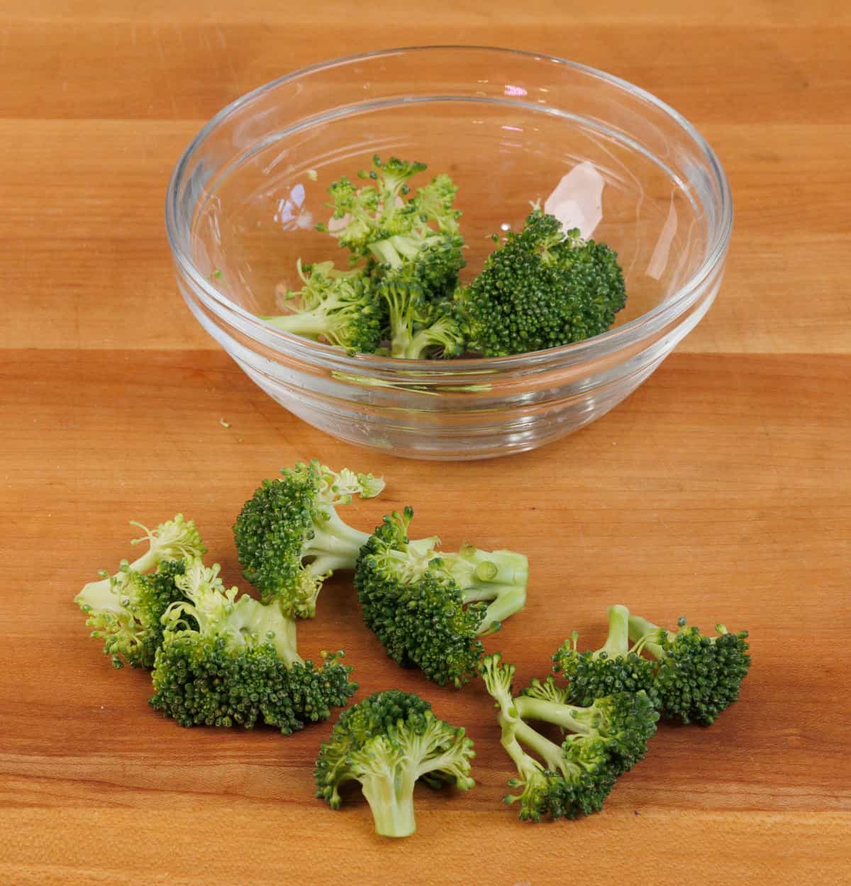 broccoli florets on a wooden cutting board