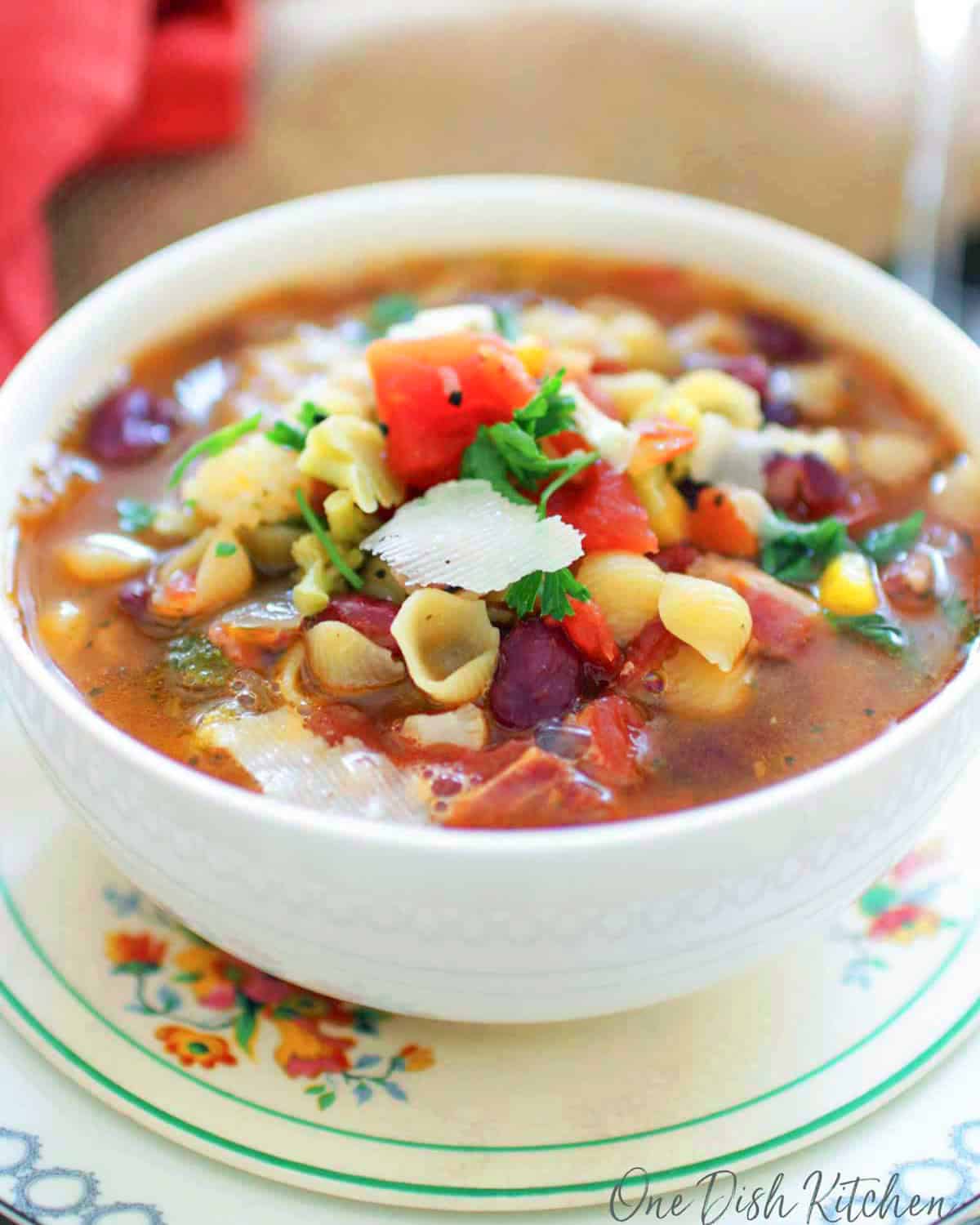 minestrone soup for one person in a white bowl.