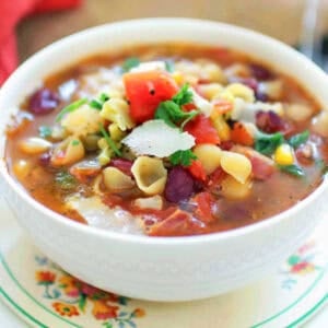minestrone soup for one person in a white bowl.