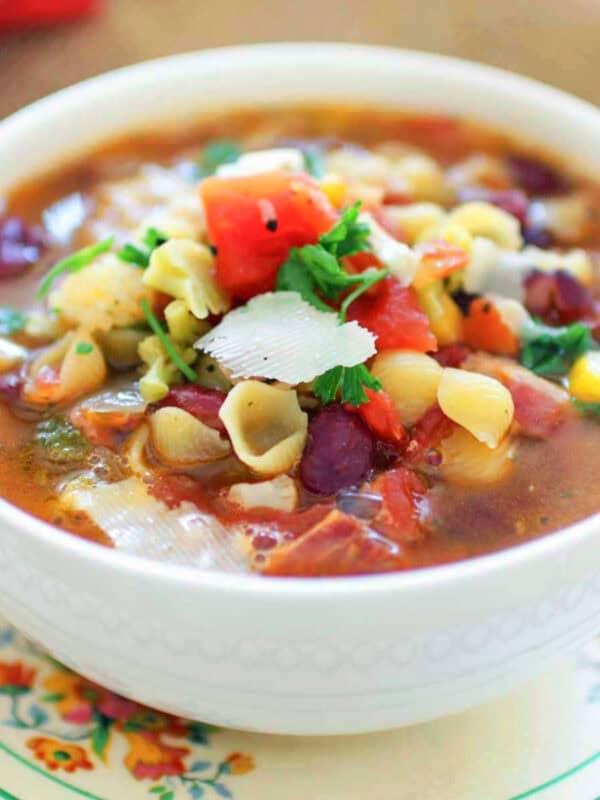minestrone soup for one person in a white bowl.