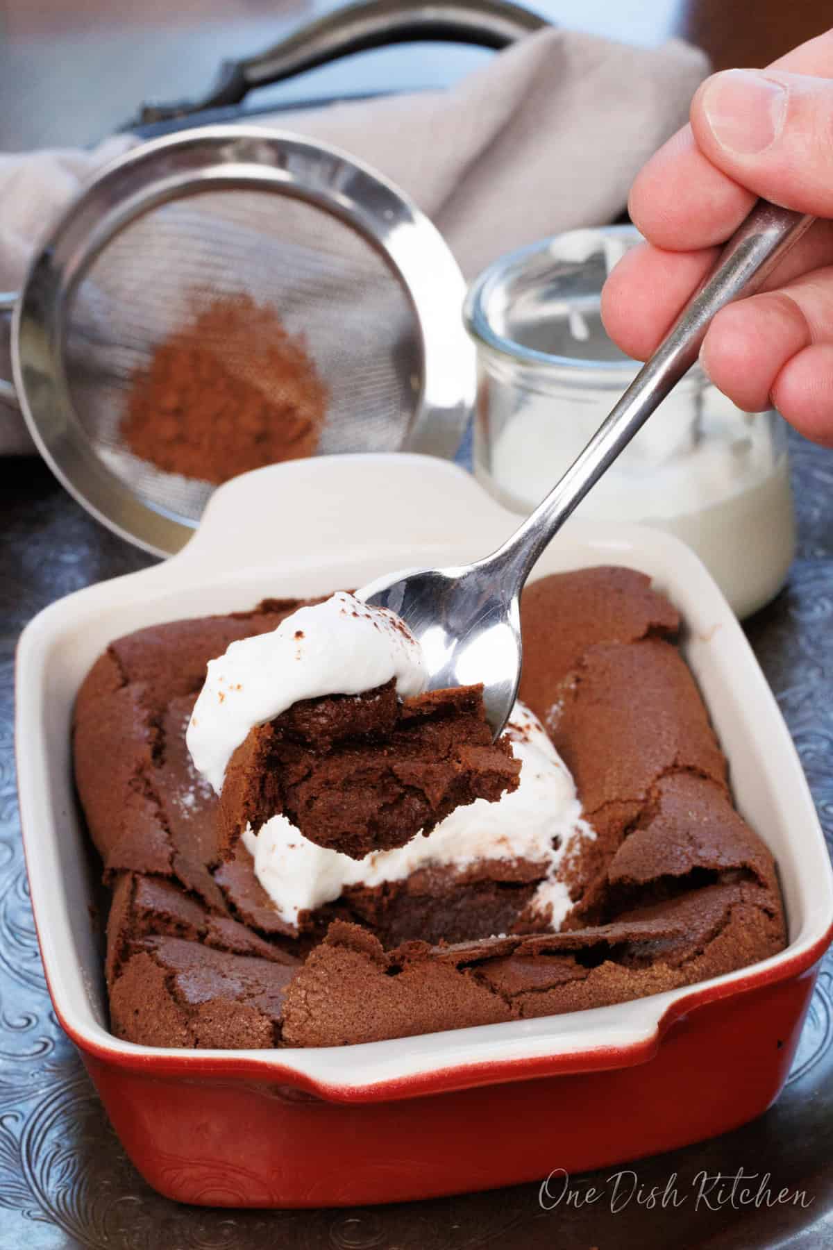 a slice of flourless chocolate cake with a spoon on the side of the dish.