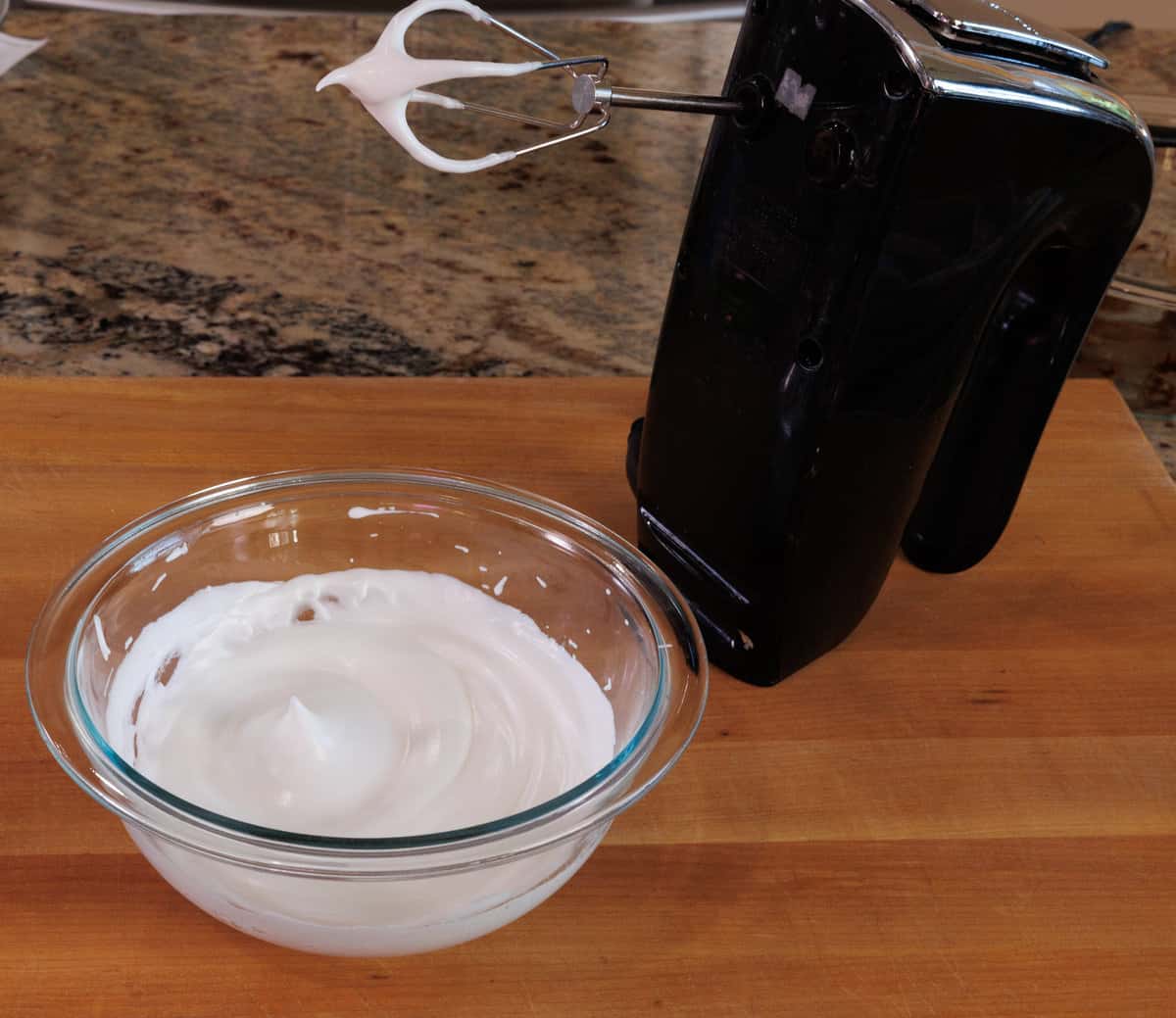 an egg white whipped to stiff peaks in a mixing bowl.