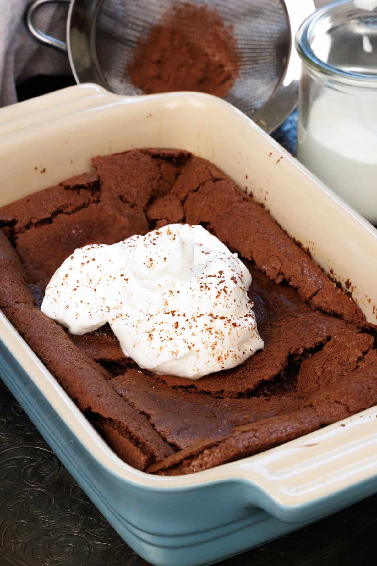 a flourless chocolate cake topped with whipped cream.