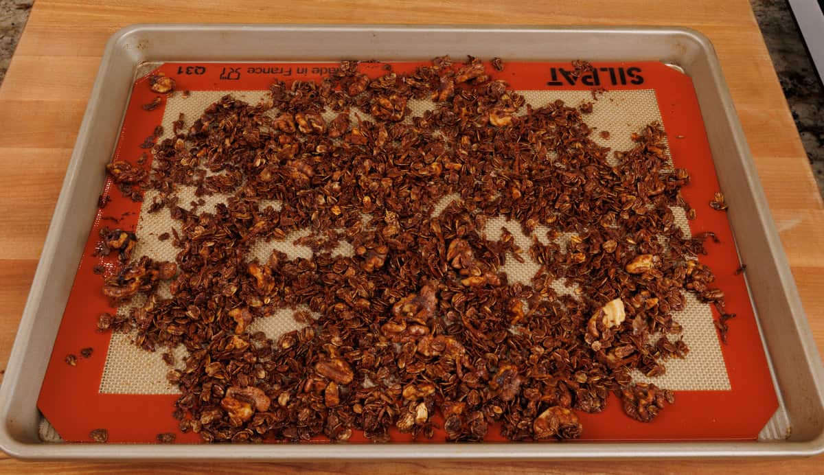 baked gingerbread granola on a lined baking sheet.