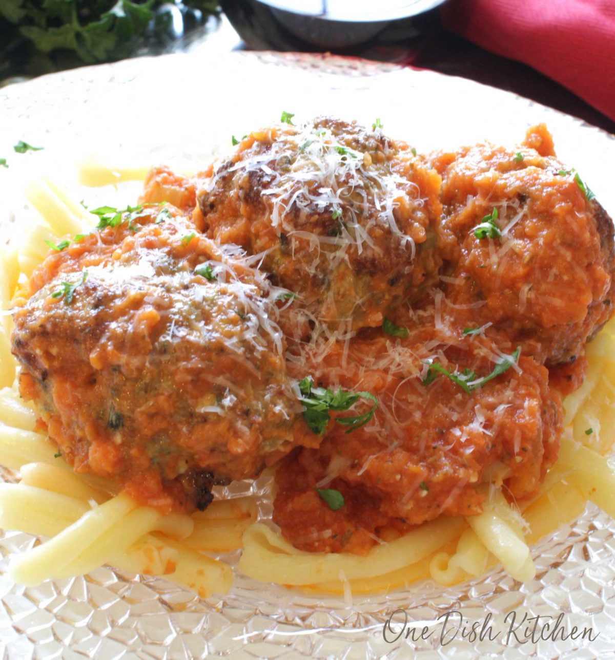 meatballs and tomato sauce over pasta on a white plate