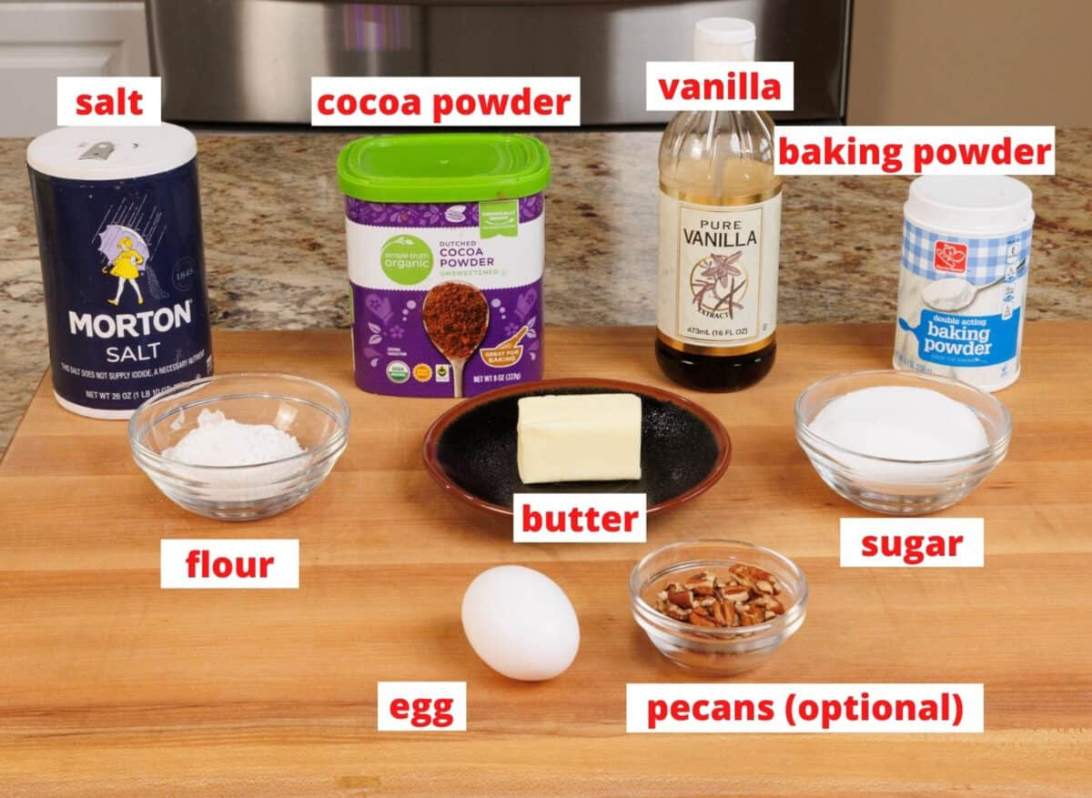 ingredients needed to make brownies on a wooden cutting board