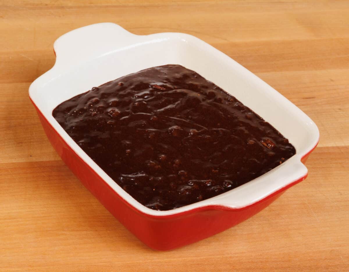 brownie batter in a small red baking dish