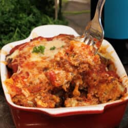eggplant parmesan in a small baking dish with a fork on the side of the dish
