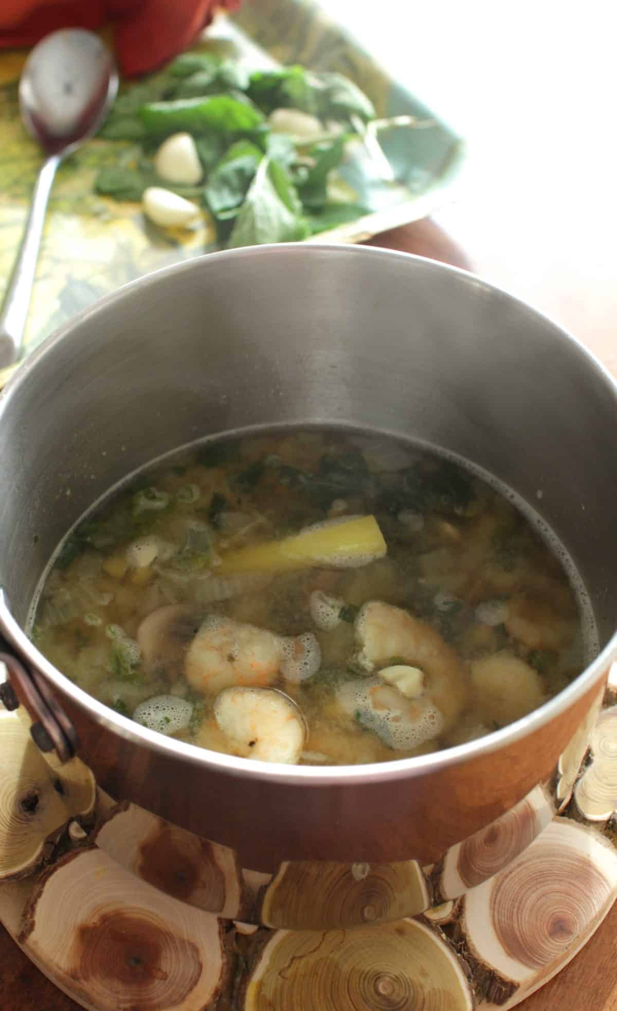 a pot filled with soup on a wooden table.