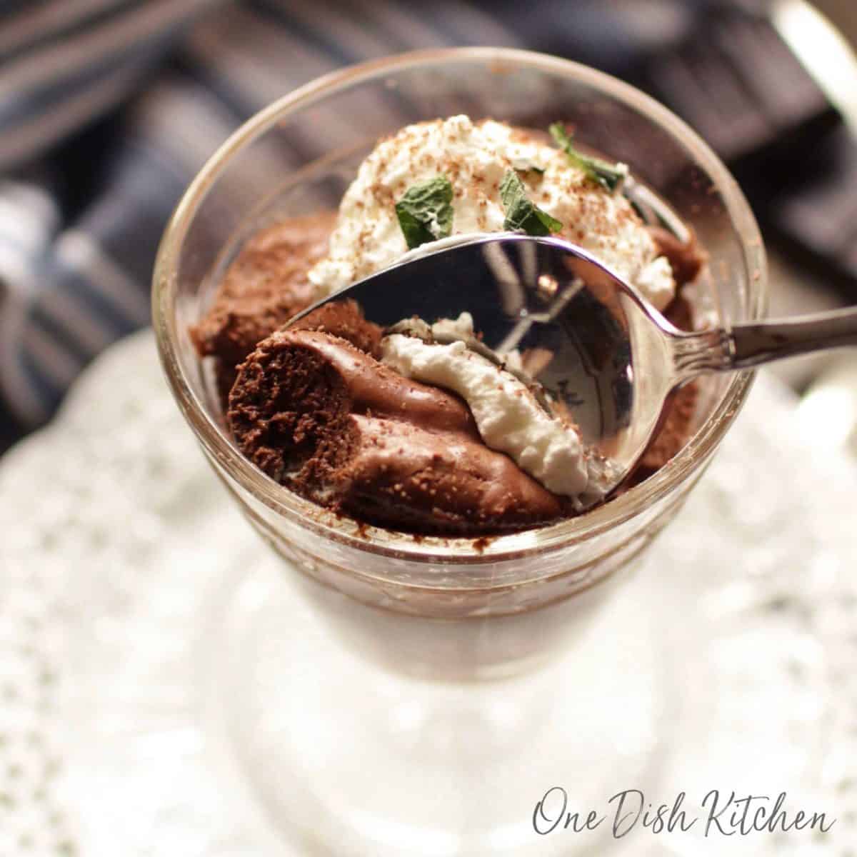 a spoonful of chocolate mousse being scooped out of a dessert glass.