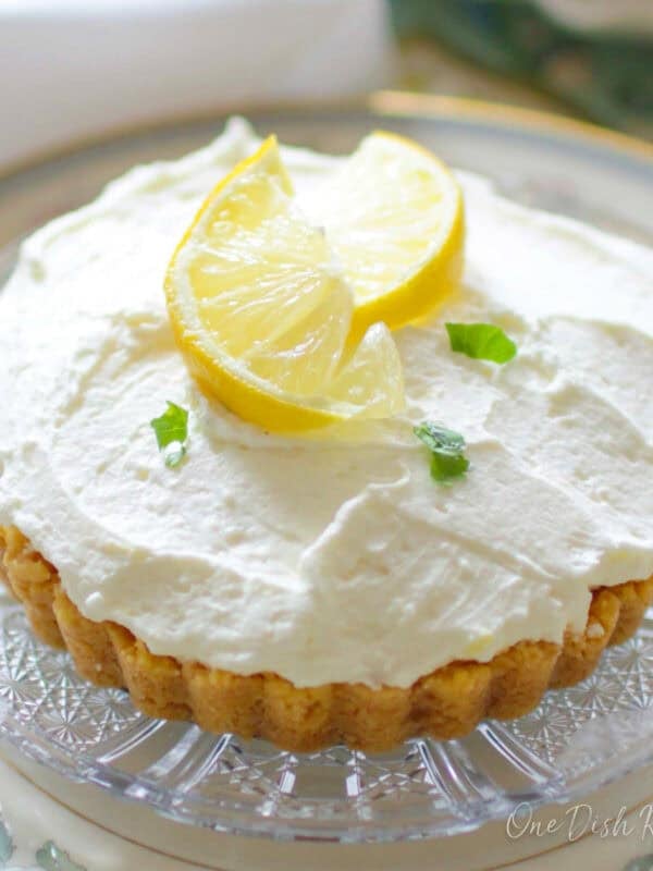 a single serving lemon cheesecake mousse in a mini pie crust on a plate.