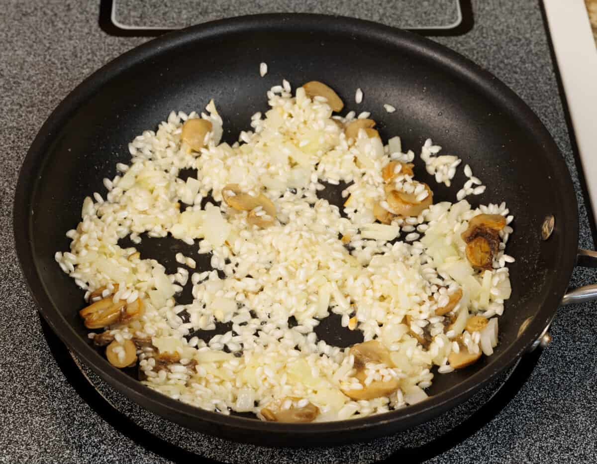 rice, mushrooms, and vegetables in a small black skillet.