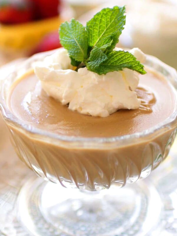 homemade butterscotch pudding in a dessert dish topped with mint