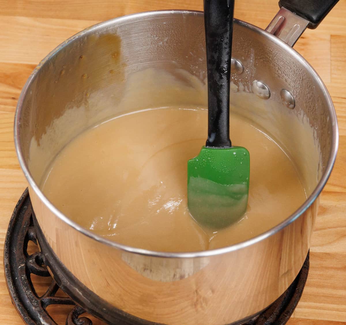 homemade butterscotch in a small saucepan cooling on a kitchen counter