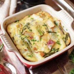 a potato and asparagus crustless quiche in a small red baking dish