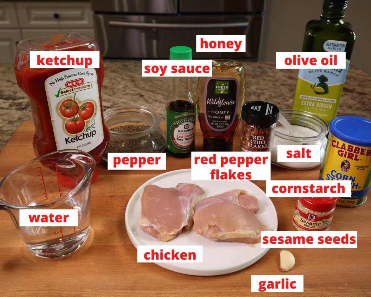 ingredients needed to make sesame chicken on a wooden table in a kitchen.