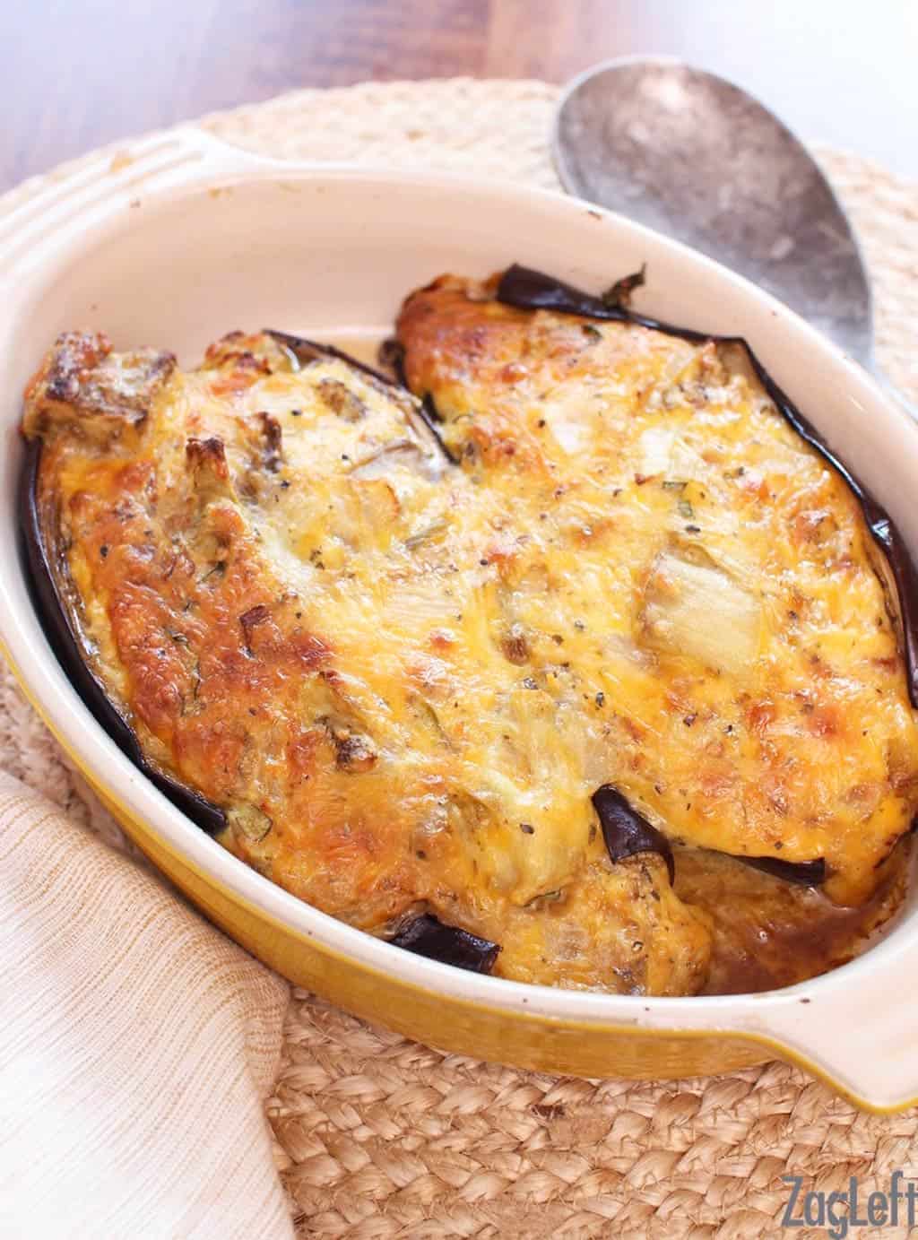 Two halves of twice baked eggplant in a cooking dish.