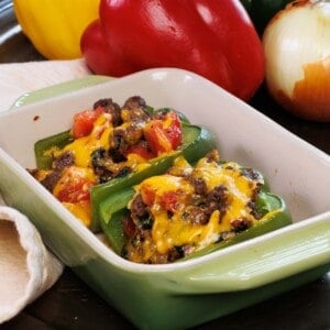 two stuffed bell peppers in a baking dish.