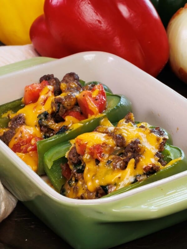 two stuffed bell peppers in a baking dish.