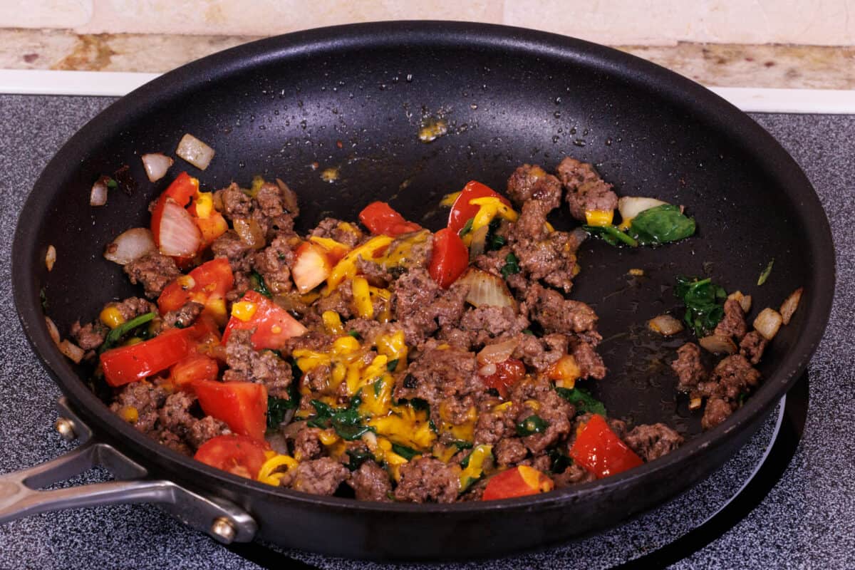 cheese, ground beef and vegetables in a black skillet