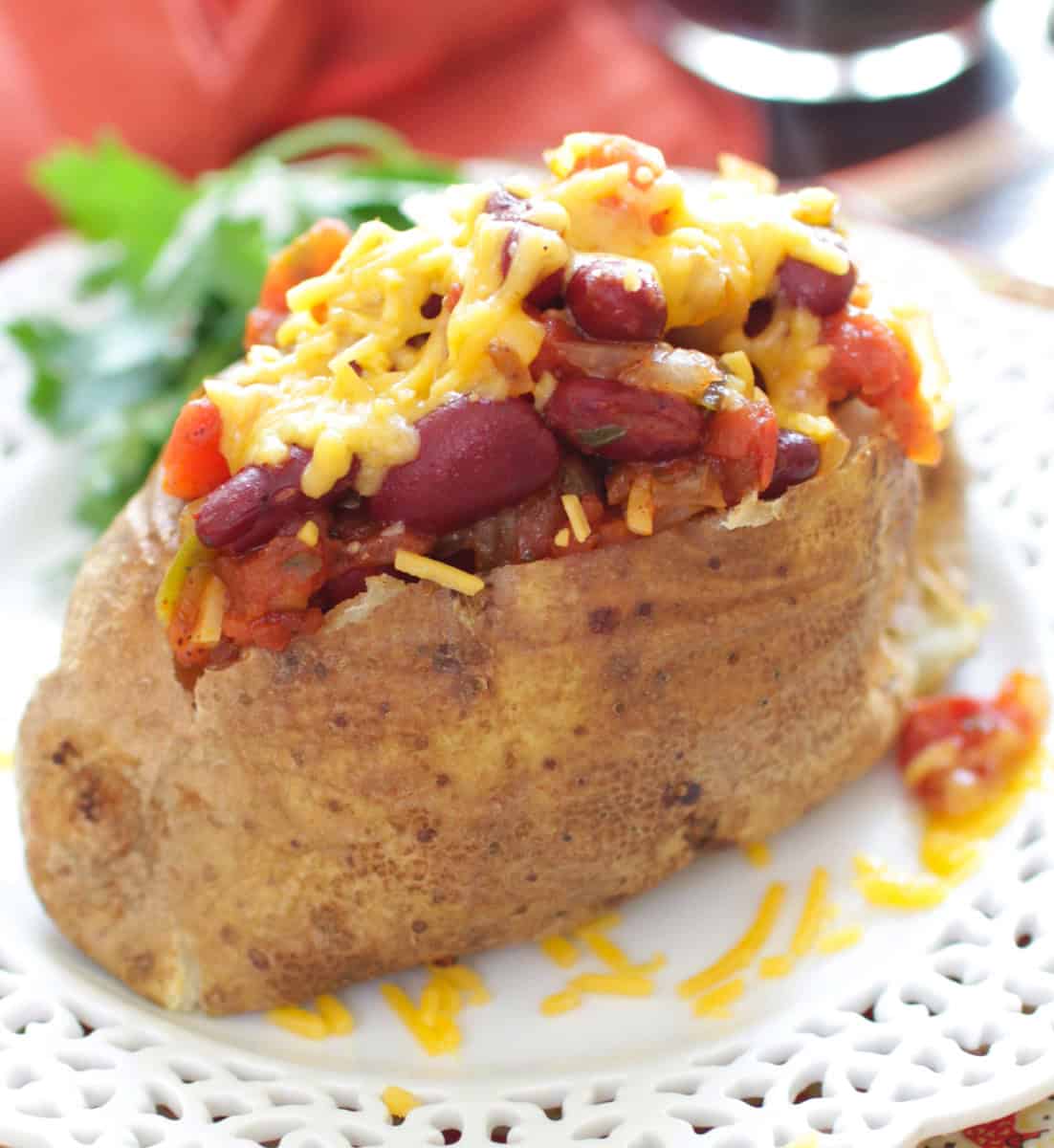 a baked potato topped with chili on a white plate.