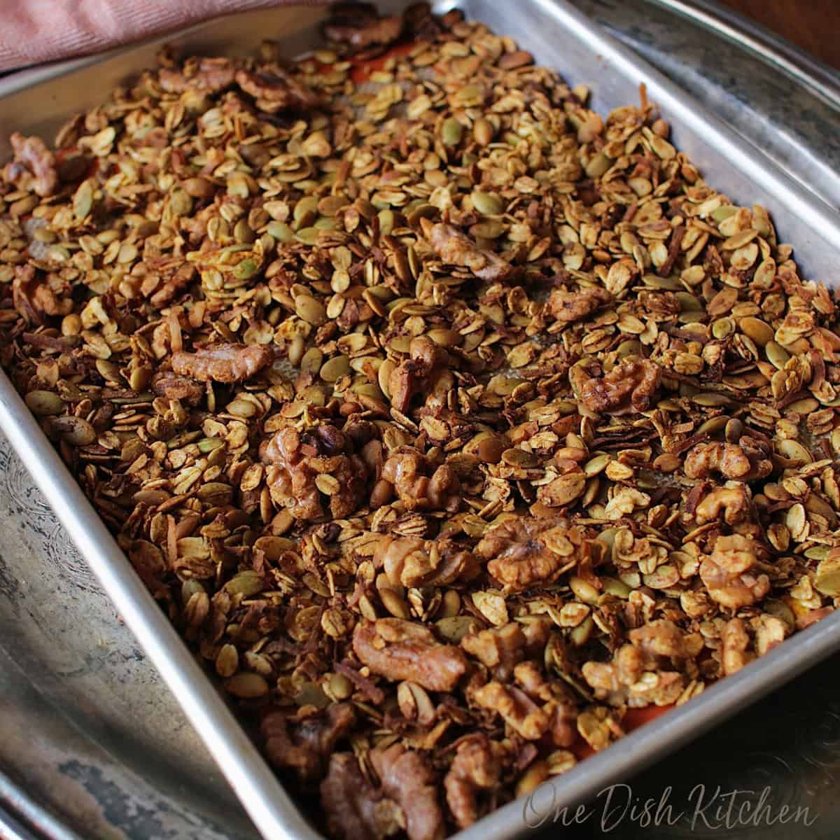 a small batch of pumpkin spice granola on a baking sheet.