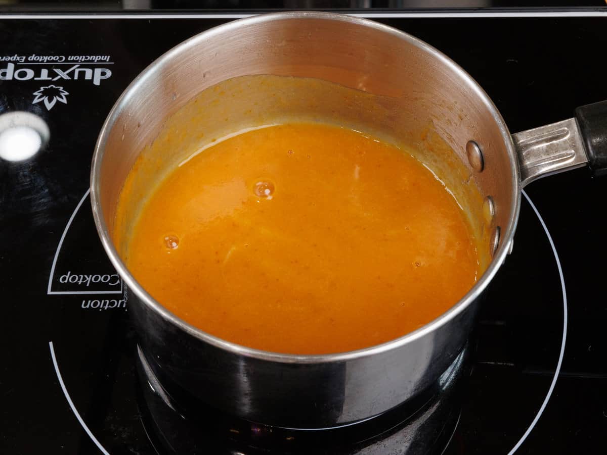 butter, maple syrup and pumpkin puree simmering in a pot on a stove