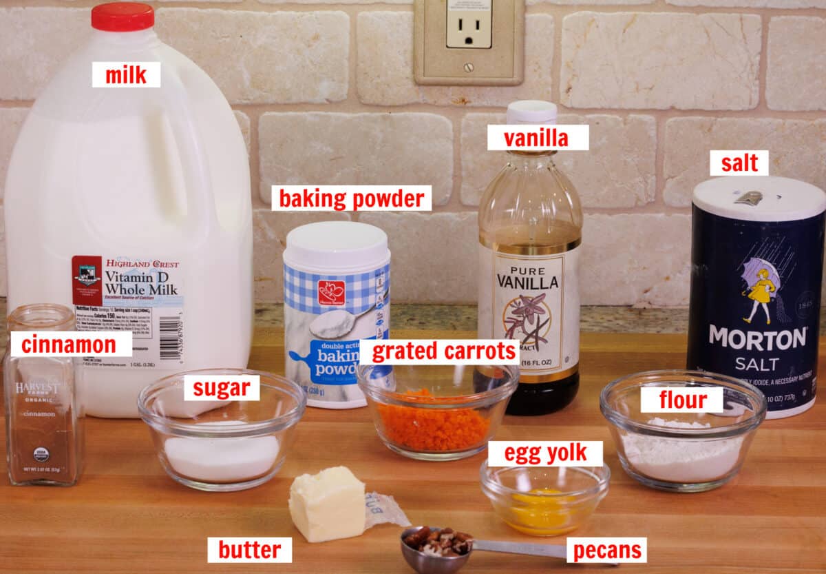 ingredients needed to make a small carrot cake on a wooden cutting board.