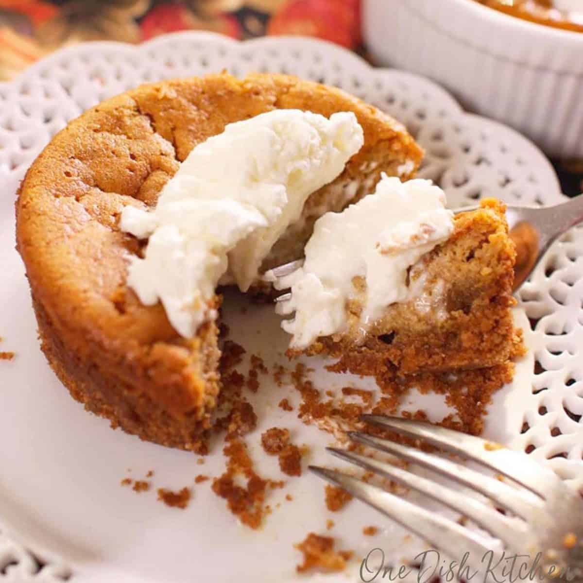 a small pumpkin pie in a ramekin topped with whipped cream and fresh mint.