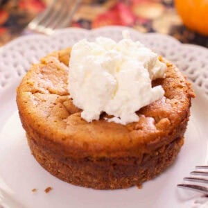 a small pumpkin pie on a white plate.