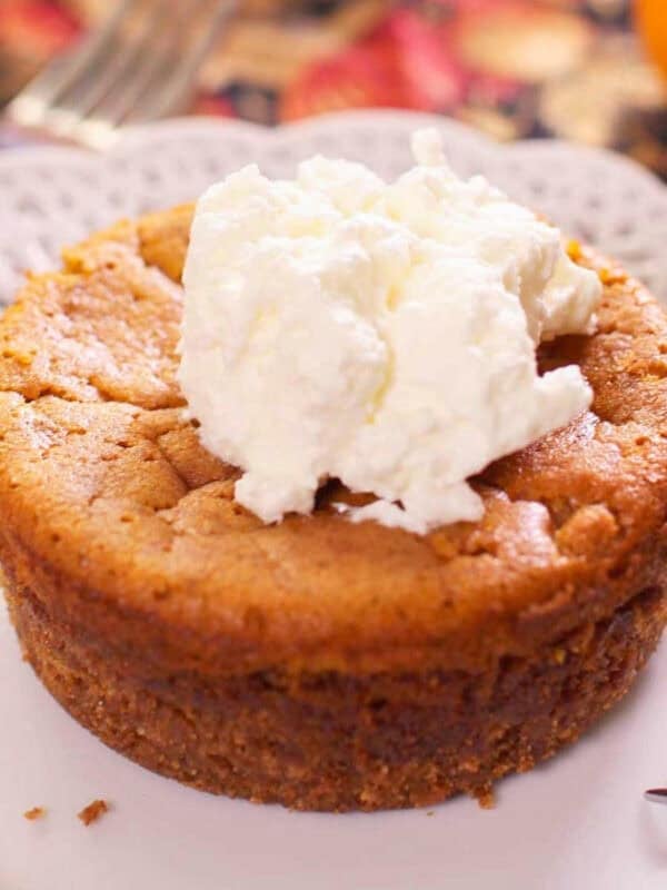 a small pumpkin pie on a white plate.
